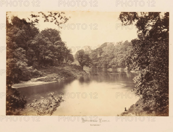 View of Bothwell Castle on the Clyde, Bothwell Castle (exterior), photograph, page, South Lanarkshire, c. 1862 - in or before 1867, photographer, paper, albumen print, height 120 mm x width 179 mm, river, landscape with tower or castle, castle, A sepia-toned photograph showing a calm river reflecting the sky and surrounding foliage, with dense trees and bushes along both banks and overhanging branches framing the scene. In the background, partially obscured by trees on a hillside, are the ruins of a stone structure. The shoreline has areas of grassy banks and a small sandy or bare patch, and the water surface has subtle ripples and reflections of the trees. The overall image has a soft, slightly faded appearance and a wide margin around the photograph.