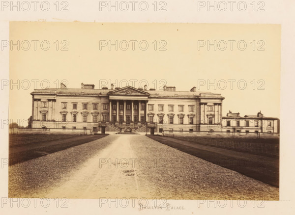 View of Hamilton Palace, Hamilton Palace, photograph, page, Lanarkshire, c. 1862 - in or before 1867, photographer, paper, albumen print, height 116 mm x width 178 mm, country-house, A large neoclassical building viewed from the front with a central portico supported by tall columns and a triangular pediment, flanked by symmetrical wings with rows of evenly spaced windows and decorative window surrounds, stone balustrades and staircases leading up to the main entrance, a wide gravel driveway running toward the building between darker planted or turfed areas, low fencing along the sides of the driveway, and a pale sky occupying the upper portion of the image.