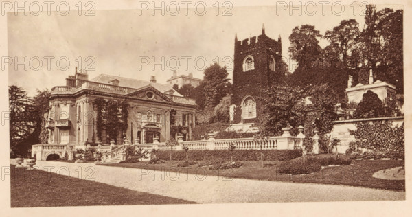 Widcombe Church and Widcombe House, Bath, View of Widcombe Church and Widcombe House in Bath, page, photomechanical print, photographer: Foote, cliché maker: Woodbury Permanent Photographic Printing Company (possibly), c. 1871 - in or before 1876, paper, Woodburytype, height 67 mm x width 136 mm, Print opposite title page, behind semi-transparent cover., church (exterior), civic architecture, edifices, dwellings, A wide sepia-toned photograph of a stately building and adjacent tower set behind a low stone balustrade, with a gravel drive and trimmed lawns in the foreground; the main building has classical architectural details including tall columns, ornate pediments, balcony elements, and multiple sash windows partially covered by climbing plants, while the tower beside it is rectangular with crenellated top and arched windows and is heavily clad in ivy; there are stone steps, decorative urns, sculpted stonework along the balustrade, dense trees and shrubbery rising behind and around t...