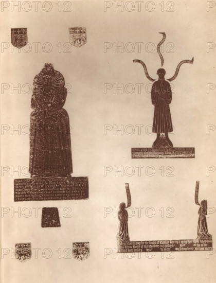 Brass objects from the churches of Bradford and Swainswick, near Bath, Brasses in Bradford and Swainswick Churches, page, photomechanical print, photographer: Foote, cliché maker: Woodbury Permanent Photographic Printing Company (possibly), c. 1871 - in or before 1876, paper, Woodburytype, Woodburytypepie, height 119 mm x width 91 mm, piece of sculpture, reproduction of a piece of sculpture, The image shows a faded, sepia-toned sheet with several carved or etched figures and small shield-like emblems arranged vertically; on the left a tall, robed figure with intricate patterned garments and a large ornate ruff sits above a rectangular panel, with two small shield emblems near the bottom; on the right a standing figure in a long robe with hands together stands atop a base with a small sculpted head below and ribbon-like banners arching above the head; lower on the page two smaller standing figures face each other, each with a narrow banner extending upward from their heads, and a long h...