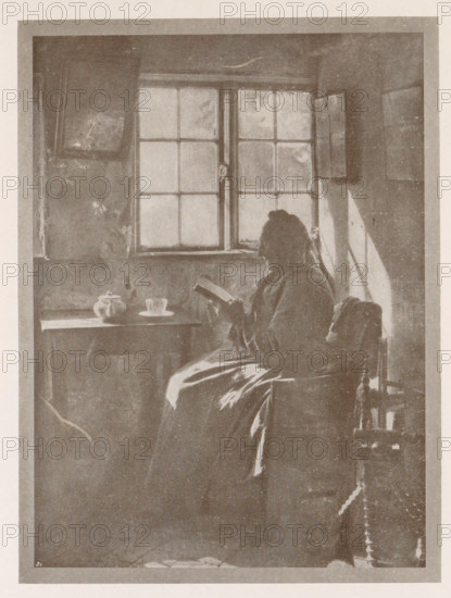 Andacht, Portrait of an unknown woman reading by the window, page, photomechanical print, inscription: 'Photographische Mitteilungen XL', monogram: 'BX', photographer: HM Carstensen, cliché maker: unknown, c. 1898 - in or before 1903, paper, autotypie, height 174 mm x width 130 mm, historical persons - BB - woman, A monochrome scene shows a person seated in profile near a multi-paned window, holding an open book. Light from the window casts a bright triangular patch on the wall beside the sitter. The figure wears a long garment with visible folds and sits on a chair with a carved back and turned legs. A small table beside the window holds a teapot and a cup on a saucer. The window panes show a mottled, slightly cloudy view and the surrounding walls have a textured, worn appearance. The image is framed by a lighter border and exhibits an overall grainy, aged quality.