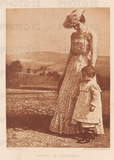 Woman with child in the landscape, Portrait in landscape, page, photomechanical print, inscription: 'Photogr. Mitteilungen XL', monogram: 'HE 1983', photographer: Hugo Erfurth, cliché maker: Büxenstein & Comp., Georg, c. 1898 - in or before 1903, paper, photoaquatint, height 164 mm x width 124 mm, historical persons - BB - woman, child, A sepia-toned image shows a woman standing beside a small child in a field with rolling hills in the background; the woman wears a long, patterned dress with a fitted bodice and a hat with a brim, and she looks downward toward the child while holding something long and dark at her side; the child stands close to her, wearing a light-colored dress with ruffled details and dark boots, looking slightly downward and away from the camera; the foreground shows textured ground and vegetation, and distant trees and undulating land occupy the middle ground under a pale sky.