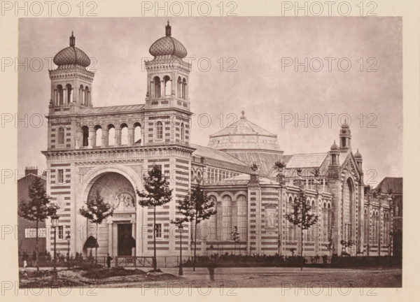 Lille Nouveau, Le Palais Rameau, View of the Palais Rameau in Lille, page, photomechanical print, inscription: 'Ou aura Lieu, le 1er avril, l'exposition des artsindustriels', inscription: 'Le Nord Contemporain, Revue Artistique & Archéologique', c. 1878 - in or before 1882, paper, Woodburytype, height 135 mm x width 190 mm, Print on third unnumbered page after page 96., palace, Lille, A sepia-toned photograph of a large ornate building with striped stonework and arched windows, featuring two square towers topped with bulbous domes and open archways, a central rounded arched entrance with carved relief above, and a low dome visible behind the main roof. The facade includes decorative cornices, pilasters, and sculpted panels, with rows of tall arched windows and smaller rectangular windows. Trees line the front of the building, partially obscuring the lower facade, and lamp posts and a fence are visible along the sidewalk. The image has a wide uniform sky above and a pale border around t...