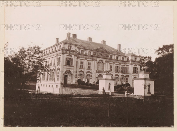 View of Château d'Avelin near Lille, Le Chateau d'Avelin, près Lille, page, photomechanical print, inscription: 'Le Nord Contemporain, Revue Historique & Archéologique', photographer: Bruckmann, Avelin, cliché maker: Ferrand, c. 1877 - in or before 1882-10-31, paper, collotype, photoprint, height 154 mm x width 215 mm, Print on third unnumbered page after page 320., castle, A large classical building with multiple windows, shutters, and decorative architectural details sits behind a low brick wall and formal gate pillars topped with animal sculptures, flanked by trees on either side; the building has a pitched roof with chimneys and a central pediment above tall arched windows, and a person stands near the entrance by one of the gate pillars with a grassy foreground in front.