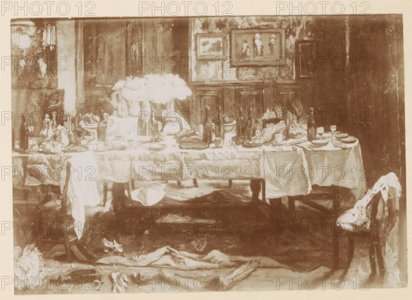 Photo reproduction of a painting of a table with remnants of a feast on it by Willem Linnig (II), photograph, reproduction, page, photographer: Alexandre van Antro, after painting by Willem Linnig (II), c. 1891 - in or before 1896, paper, daylight collodion silver print, height 120 mm x width 171 mm, wedding feast, wedding meal, laid table as still life (broken, damaged tableware, etc.), A long table covered with a white tablecloth stretches across the scene, cluttered with bottles, bowls, cups, plates, serving dishes, and vases holding large white flowers; napkins and cloths drape over the table edge and hang toward the floor. Behind the table a paneled wall displays framed paintings, and a dark curtain or doorway occupies one side. Chairs sit at either end of the table, one with a draped cloth, while the floor in front of the table is strewn with more fabric and a few scattered objects. The image has a muted, sepia-toned appearance and an overall painterly texture.