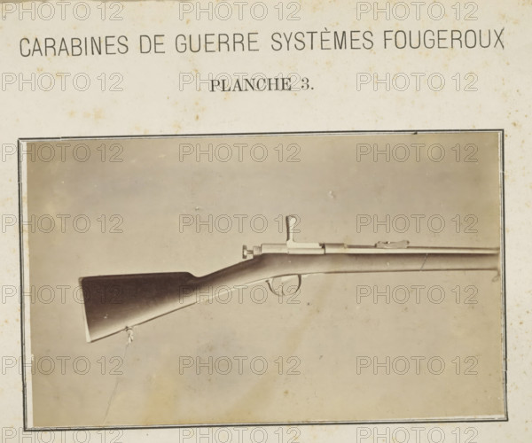 Butt of a rifle, photograph, page, inscription: 'Carabines de guerres systèmes Fougeroux', number: 'Planche 3.', photographer: Edouard Magis, Liège, c. 1857 - in or before 1867, paper, albumen print, height 159 mm x width 97 mm, Image in section at the back., firearms: rifle, A sepia-toned photograph of a rifle displayed horizontally within a dark rectangular border on aged paper, showing the wooden butt, curved stock, trigger guard, and metal bolt mechanism, with a sling attached near the butt and the barrel extending toward the right, all set against a plain, slightly mottled background.