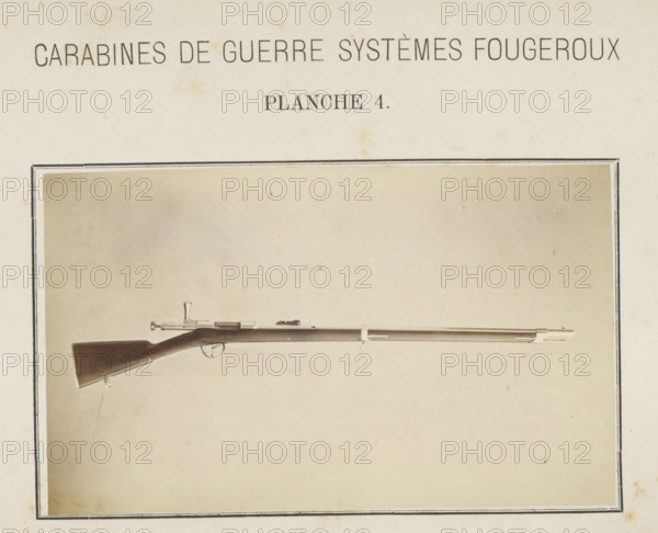 Rifle, photograph, page, number: 'Planche 4.', inscription: 'Carabines de guerres systèmes Fougeroux', photographer: Edouard Magis, Liège, c. 1857 - in or before 1867, paper, albumen print, height 159 mm x width 97 mm, Image in section at the back., A sepia-toned photograph shows a long rifle positioned horizontally within a rectangular frame; the rifle has a dark wooden stock with a curved butt, a metal trigger guard and bolt action near the stock, a long slender barrel with metal fittings and a front sight, and small hanging straps attached beneath the stock, all set against a plain light background with mild discoloration and a thin decorative border around the image.