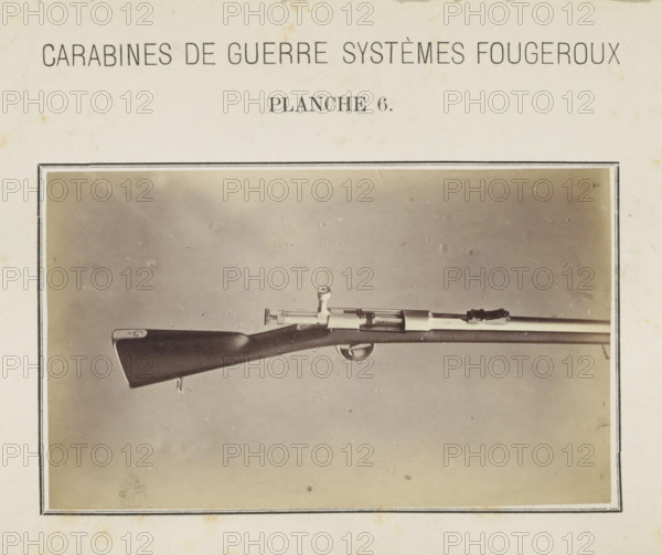 Part of a rifle, photograph, page, number: 'Planche 6.', inscription: 'Carabines de guerres systèmes Fougeroux', photographer: Edouard Magis, Liège, c. 1857 - in or before 1867, paper, albumen print, height 158 mm x width 96 mm, Image in section at the back., firearms: rifle, A sepia-toned photograph centered on a horizontally positioned bolt-action rifle mounted against a plain backdrop, showing a dark wooden stock with a smooth, rounded butt, a metal trigger guard and visible trigger, a bolt handle protruding upward, and a long slender barrel with metal fittings; the photo is bordered by a thin double-lined frame and sits on aged paper with a printed heading across the top and faint foxing marks.