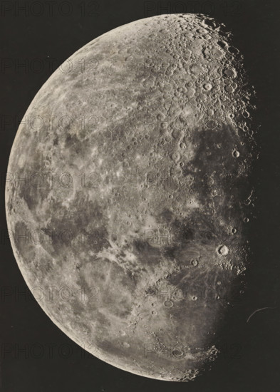 View of the moon, Photographie lunaire obtenue a l'observatoire de Paris, page, photomechanical print, inscription: 'Société Belge d'Astronomie Atlas Lunaire Pl. B.', inscription: '1896. Février 23. _ 6.H. 5M. Temps Moyen de Paris', maker: Loewy et Puiseux, maker: Maurice Loewy, maker: Pierre Henri Puiseux, maker: J. Heuse, 1896-02-23 - in or before 1898, paper, photoaquatint, height 193 mm x width 131 mm, moon as celestial body, A close-up view of a large cratered celestial surface occupying most of the frame against a dark background, showing varied textures from smooth, lighter plains to heavily pockmarked, shadowed regions with numerous circular depressions and raised rims, subtle tonal gradations across the terrain, visible ridges and shadows accentuating depth, and a curved limb delineating the edge of the sphere.