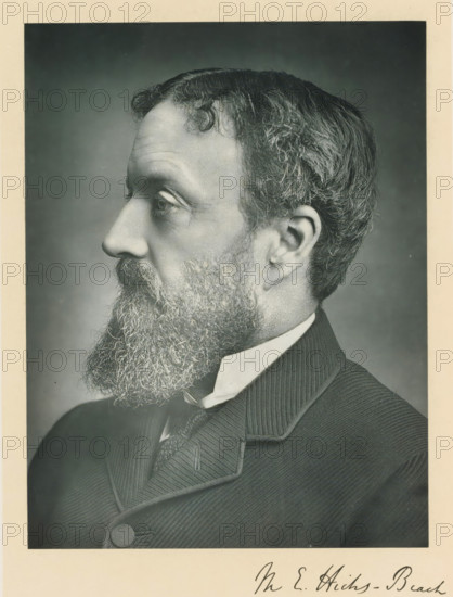 The right honorable sir Michael Edward Hicks-Beach, photograph, page, inscription: '17, Baker St, London, W.', annotation, photographer: Russell & Sons, c. 1893 - c. 1903, paper, carbon print, height 227 mm x width 171 mm, Person, Michael Edward Hicks Beach, historical persons (portraits and scenes from the life) ((full) bust portrait), A black and white portrait showing a close-up profile of a man facing left with a full, curly beard and mustache, short wavy hair with visible texture, and a prominent ear; he is wearing a high-collared shirt, a patterned tie, and a dark, textured jacket with a rounded button and a notched lapel, all set against a plain, softly shaded background with a light border around the image.