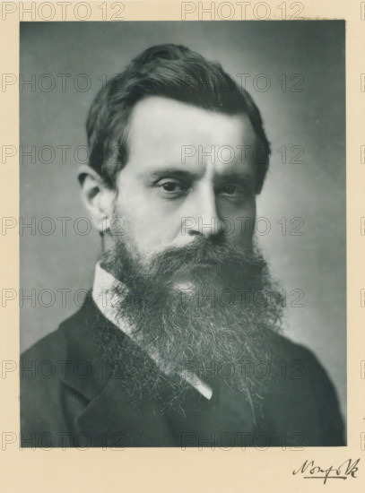 His grace the duke of Norfolk, KG, photograph, page, annotation, inscription: '55, Baker St, London, W.', photographer: Elliott & Fry, c. 1893 - c. 1903, paper, carbon print, height 227 mm x width 171 mm, Person, Henry Fitzalan-Howard, historical persons (portraits and scenes from the life) ((full) bust portrait), A close-up black-and-white portrait of a man with a full, long beard and mustache, dark hair combed back, and a serious facial expression, wearing a dark suit jacket and a light-colored shirt collar visible beneath the beard, framed by a light border around the photograph.