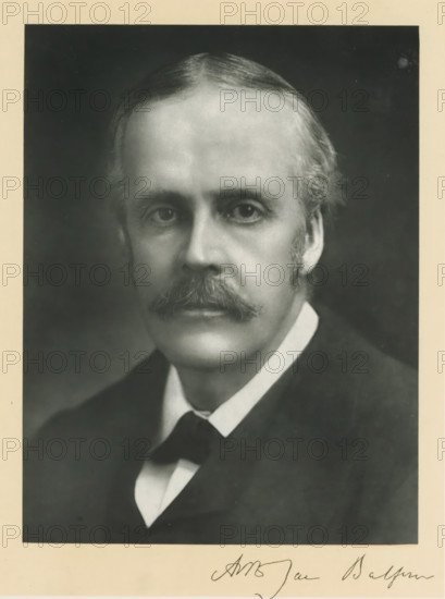 The right honorable Arthur James Balfour, photograph, page, inscription: '55, Baker St, London, W.', annotation, photographer: Elliott & Fry, c. 1893 - c. 1903, paper, carbon print, height 227 mm x width 171 mm, Person, Arthur James Balfour, historical persons (portraits and scenes from the life) ((full) bust portrait), A black and white portrait of a middle-aged man shown from the chest up, with a high forehead and neatly combed hair, a full mustache, sideburns, and a composed expression, wearing a dark coat over a white shirt and a dark bow tie, set against a dark background and surrounded by a light-colored border.