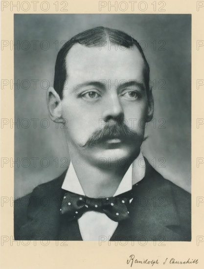 The right honorable the late lord Randolph Spencer Churchill, photograph, page, annotation, inscription: 'Rue d'Anjou, 51, Paris.', photographer: Félix Nadar, Paris, c. 1890 - c. 1895, Félix Nadar, photographer, paper, carbon print, height 229 mm x width 171 mm, Person, Lord Randolph Churchill, historical persons (portraits and scenes from the life) ((full) bust portrait), A black-and-white portrait of a man from the shoulders up showing a neatly combed hairstyle with a center part, a prominent curled mustache, light-colored eyes looking slightly to the side, and a high-collared shirt with a dark jacket and a polka-dotted bow tie.
