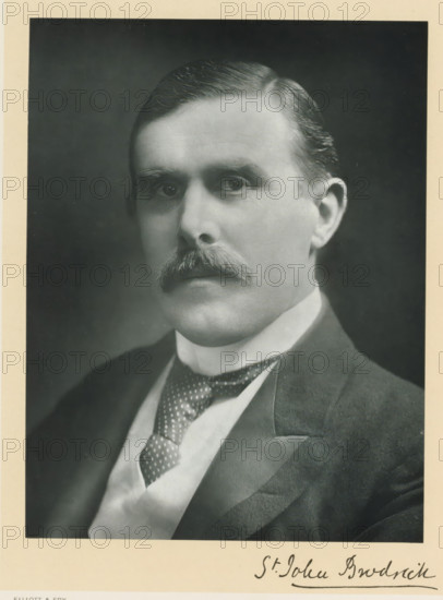 The right honorable William St. John Fremantle Brodrick, photograph, page, inscription: '55, Baker St, London, W.', annotation, photographer: Elliott & Fry, c. 1893 - c. 1903, paper, carbon print, height 227 mm x width 171 mm, Person, William St. John Fremantle Brodrick, historical persons (portraits and scenes from the life) ((full) bust portrait), A sepia-toned portrait of a middle-aged man from the chest upward, facing slightly to the viewer's left, with neatly combed dark hair, a prominent mustache, and a solemn expression; he is wearing a dark suit jacket with a light waistcoat and a patterned necktie, and the image is bordered by a light margin.