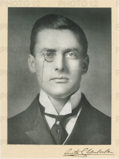 The right honorable J. Austen Chamberlain, photograph, page, annotation, inscription: '25, Old Bond St, London, W.', photographer: Bassano & Co., c. 1893 - c. 1903, paper, carbon print, height 228 mm x width 171 mm, Person, Austen Chamberlain, historical persons (portraits and scenes from the life) ((full) bust portrait), monocle, single lorgnette, A black-and-white portrait of a man from the shoulders up showing a close-cropped hairstyle combed back, a smooth forehead, prominent eyes with one eye framed by a circular eyepiece attached to a thin chain, straight nose, closed lips, and a clean-shaven jaw. He wears a high starched collar with pointed ends, a tie with a visible tie pin, and a dark jacket visible at the edges. The image has a pale border around the photograph.