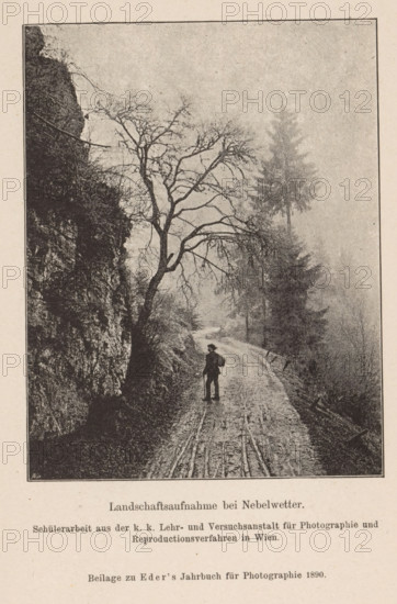 Fog landscape with figure on the road, page, photomechanical print, monogram: 'AC', inscription: 'Landschaftsaufnahme bei Nebelwetter., Beilage zu Eder's Jahbruch für Photographie 1890', maker: KK Lehr- und Versuchsanstalt für Photographie, c. 1885 - in or before 1890, KK Lehr- und Versuchsanstalt für Photographie, paper, autotypie, height 119 mm x width 93 mm, Print on twenty-third unnumbered page after page 400., fog, landscapes (landscape with figures, staffage), A vertical black-and-white illustration shows a narrow winding dirt road bordered on the left by a steep rocky cliff face and on the right by tall slender trees fading into mist; a bare-branched tree arches over the road from the left, and a solitary figure wearing a hat and carrying a bag stands on the road facing away, holding a walking stick, while the surface of the road displays visible tracks and ruts.