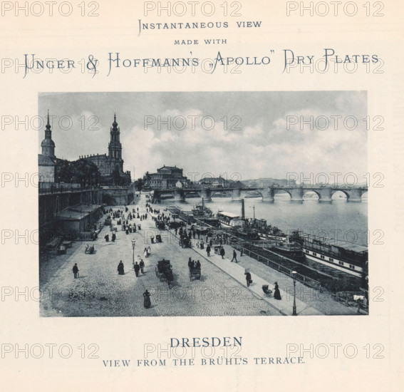 Dresden view from the Brühl's terrace, View of Dresden from the Brühlsche Terrasse, page, photomechanical print, It is an advertisement for negative plates by Unger & Hoffmann., inscription, inscription: 'Instantaneous view made with Unger & Hoffmann's, Apollo' Dry plates', maker: anonymous, Dresden, c. 1892, Saxony, paper, collotype, photogravure, height 108 mm x width 158 mm, Print is loose in the book., bridge in city across river, canal, street (city(-scape) with figures, staffage), A sepia-toned photograph shows a riverside scene with a cobblestone promenade along the water where numerous people walk, stand, and sit, some in groups and some alone, with a few horse-drawn carriages on the road and a person pushing a pram near a lamppost; several moored boats and larger vessels line the riverbank beside wooden docks and piers; a stone arched bridge spans the river in the background beneath a cloudy sky; on the left a riverside embankment rises to buildings and prominent towers with o...