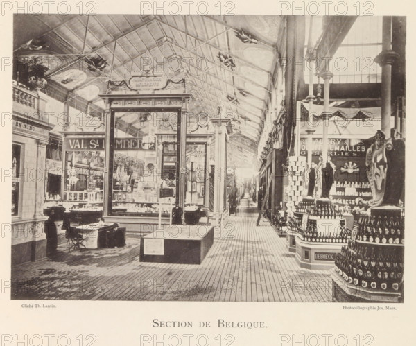 Section de Belgique, Expositie van Belgische beelden tijdens de wereldtentoonstelling te Antwerpen, page, photomechanical print, photographer: Th. Lantin, Antwerp, clichémaker: Joseph Maes, 1894, paper, collotype, light print, height 160 mm x width 220 mm, world fair, world exhibition, exhibition, show, A sepia-toned indoor scene of a long covered hall with a high pitched glass and metal roof and decorative ceiling panels, flanked by tall columns and ornate display booths, a central glass-fronted pavilion with framed panels and ornamental trim, wooden plank flooring leading down a narrow aisle lined with displays, shelving and stacked bottles, a tiered circular display of bottles in the foreground to the right, mannequins or sculpted figures among the displays, a few people in period clothing near the front left including a seated person at a small table and a standing figure, hanging lights and decorative garlands along the upper walls, and various framed mirrors, shelving units and m...