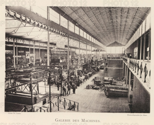 Galerie des machines, Interior of the machine hall during the World Exhibition in Antwerp, page, photomechanical print, photographer: Th. Lantin, Antwerp, cliché maker: Joseph Maes, 1894, paper, collotype, photogravure, height 160 mm x width 219 mm, interior, representation of a building, world fair, world exhibition, exhibition, show, machines, parts of machines, tools and appliances, A wide interior view of a large industrial hall with a high arched roof supported by rows of slender columns and trusses, long clerestory windows along the upper walls, and patterned roofing ribs; the floor area contains numerous machines, engines, and metal frameworks arranged in rows with scaffolding, platforms, and workbenches, and various parts, crates, and coiled materials scattered around; a balustraded upper walkway runs along one side above a stairway leading down to the main floor; several workers in dark clothing stand near the foreground among the equipment; hanging decorative fabric swags lin...