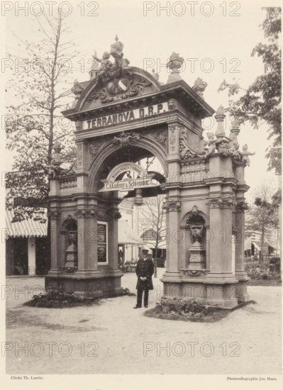 Pavillon au jardin, Gate at the world exhibition in Antwerp, page, photomechanical print, photographer: Th. Lantin, Antwerp, printer (person): Joseph Maes, 1894, printer (person), paper, collotype, photoprint, height 218 mm x width 162 mm, facade (of house or building), gate, entrance, world fair, world exhibition, A sepia photograph of an ornate stone archway with decorative sculptures and reliefs, flanked by two pillars each featuring carved niches and ornamental vases; cherub statues and ornamental finials adorn the top of the arch, and a rounded decorative element sits within the central opening; a man in a dark uniform with a hat stands beneath the arch facing the camera; tents or striped awnings and trees are visible behind and to the sides of the structure, and a gravel or dirt ground extends in front of the arch.