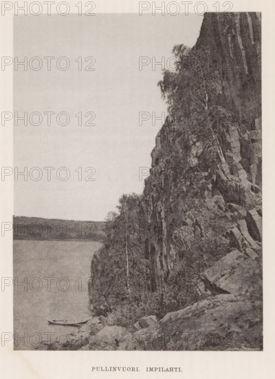 Rock wall on a body of water with an empty canoe, Pullinvuori Impilahti, page, photomechanical print, photographer: Impi Backman, cliché maker: anonymous, printer (person): Weilin & Göös, c. 1888 - c. 1893, printer (person), paper, autotypie, height 212 mm x width 157 mm, rowing-boat, canoe, landscapes with waters, waterscapes, seascapes (in the temperate zone), rock-formations, Karelia, A tall rocky cliff covered with trees rises on the right side of the image, showing exposed stone faces and scattered vegetation; at the base of the cliff a narrow shoreline meets a calm body of water where a small rowboat rests near the edge; the left side of the image shows the open water stretching toward a distant, low-lying horizon under a mostly clear sky.