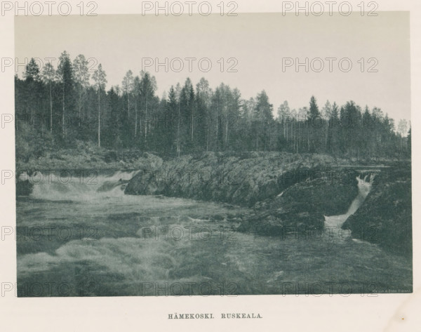 View of rocks and a rapid in a river, Hämekoski. Ruskeala, page, photomechanical print, photographer: Impi Backman, cliché maker: anonymous, printer (person): Weilin & Göös, c. 1888 - c. 1893, printer (person), paper, autotypie, height 157 mm x width 221 mm, river, rocks, rapids, Karelia, A wide river scene with turbulent water flowing over and around dark rocky outcrops in the foreground and midground, a narrow cascade of water dropping between rocks at the right, and a dense treeline of tall slender trees along the far bank beneath a pale, empty sky.