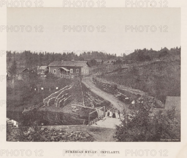 View of a path through a hilly landscape with houses, Sumerian mylly. Impilahti, page, photomechanical print, photographer: Impi Backman, cliché maker: anonymous, printer (person): Weilin & Göös, c. 1888 - c. 1893, printer (person), paper, autotypie, height 161 mm x width 210 mm, road, path, bridge, (high) hill, civic architecture, edifices, dwellings, Karelia, A grainy black-and-white photograph of a rural scene showing a dirt road curving through a fenced landscape toward a cluster of wooden buildings, including a house with a pitched roof and a small covered porch, surrounded by fences and stacks of cut logs; in the foreground there is a wooden walkway or platform with several figures standing on it and laundry hanging nearby, a body of water reflecting parts of the scene, and scattered farm implements and barrels; the background features a tree line of coniferous trees and gently rolling hills under a pale sky.