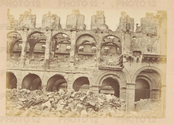 Ministère des finances, View of a destroyed Ministry of Finance, photograph, page, 1871, photographer, paper, albumen print, albumendruk, height 101 mm x width 151 mm, ruin of a dwelling, house, castle, palace, Paris, A large stone building facade with multiple rounded arches and upper-level arched openings, many of the stones chipped and crumbling, a pile of rubble and broken masonry in front of the arches, exposed structural elements and partial interior walls visible through the openings, vertical supports and carved stone details around some arches, and a generally worn and damaged surface across the visible sections.