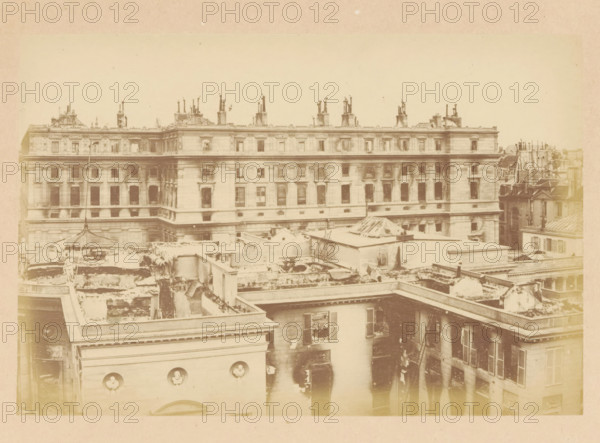 Conseil d'etat & legion d'honneur, View of a destroyed building of the Council of State, photograph, page, 1871, photographer, paper, albumen print, albumendruk, height 101 mm x width 151 mm, ruin of a dwelling, house, castle, palace, A wide, faded photograph shows the upper façades and rooftop areas of a large stone building with rows of rectangular windows and decorative cornices, chimneys and ornate rooftop sculptures along the roofline, and several lower adjoining structures in the foreground with flat roofs, exposed roof interiors, rubble, and partial walls; one rooftop area contains a skeletal glass-roof structure, another has a curved metal framework and a small statue-like figure, and window shutters and damaged plaster are visible on the nearer walls, all rendered in soft sepia tones.