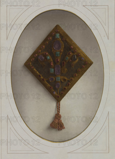 Fibula of King Louis IX of France, Fermail du manteau royal de Saint-Louis, Musée National du Louvre Galerie d'Apollon, page, photomechanical print, inscription: 'XIIIe siècle', inscription: 'ateliers de photochromie du moniteur', photographer: Léon Vidal, Paris, cliché maker: Léon Vidal, c. 1876 - c. 1883, Léon Vidal, photographer, cliché maker, paper, photochrom, height 251 mm x width 176 mm, coat, cape, fibula, safety pin, A diamond-shaped ornament with a central panel of dark material set inside a gold-toned border, decorated with multiple faceted stones in purple, pink, and teal tones arranged symmetrically, with small round settings along the edge and larger oval and rectangular settings toward the center, a braided cord attached at the lower point leading to a tasseled end in a muted pink color, all mounted against an oval matte background framed by a pale border with thin decorative lines.