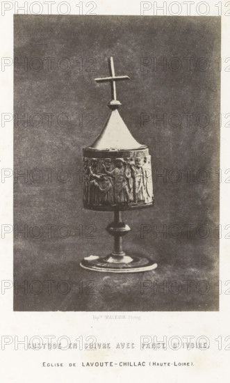 Ivory reliquary from Lavoûte-Chilhac, Custode en cuivre avec panse d'ivoire, photograph, page, inscription: 'eglise de Lavoute-Chillac (Haute-Loire).', number: 'PL. 16.', photographer: Hippolyte Malègue, France, c. 1850 - in or before 1857, Hippolyte Malègue, photographer, paper, salted paper print, height 195 mm x width 136 mm, relics (and reliquaries), A photographic image of a chalice-like object standing on a circular base with a central stem supporting a cylindrical body topped by a conical lid and a simple cross finial; the cylindrical section is decorated with a raised relief showing standing human figures in robes; the object appears metallic with a light-colored lid and darker relief band, set against a plain textured background and framed by a white border.