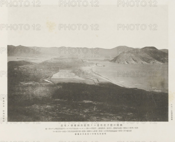 View of the Port Arthur straits from the Lantseying forts at Port Arthur, page, photomechanical print, inscription: 'The fall of Port Arthur.', inscription: 'The flat hill on the right end is, The high hill on the left is Peiyuh-shan.', photographer: Ordnance Survey, Manchuria, cliché maker: Kazumasa Ogawa, Japan, 1894-11-28, paper, collotype, photoprint, height 197 mm x width 272 mm, city-view in general, 'veduta', gulf, bay, A grayscale panoramic scene shows a coastal landscape with a wide beach curving along the shoreline next to calm water, rising rocky headlands and cliffs on the right, lower rolling hills and flat plains extending inland, and distant mountains forming a jagged horizon; the foreground consists of a darker, textured expanse of land with faint paths and irregular patches, while various lighter, rectangular shapes on the plain suggest constructed surfaces near the coast, and the sky above is pale and mostly empty with a few subtle blemishes.