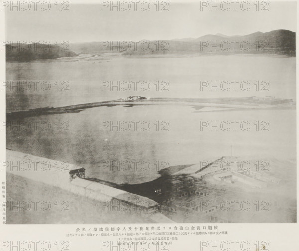 A distant view of the Old tiger's tail fort and the Jentse earworks from the Hwangkin hill forts, Port Arthur, page, photomechanical print, inscription: 'The place where the flag-staff stands is Jentse, to the left of which is a torpedo-station.', inscription: 'The fall of Port Arthur.', photographer: Ordnance Survey, Manchuria, cliché maker: Kazumasa Ogawa, Japan, 1894-11-30, Ordnance Survey, Kazumasa Ogawa, photographer, cliché maker, paper, collotype, photoprint, height 212 mm x width 278 mm, fortress, straits, narrows, A wide, pale grayscale view of a body of water bordered by distant hills under a light sky, with a narrow strip of land or causeway extending across the middle distance and small low structures clustered on it, the foreground showing a high stone or concrete wall edge and rooftop areas with rectangular openings and building outlines, and the overall image appearing faded and soft in contrast.