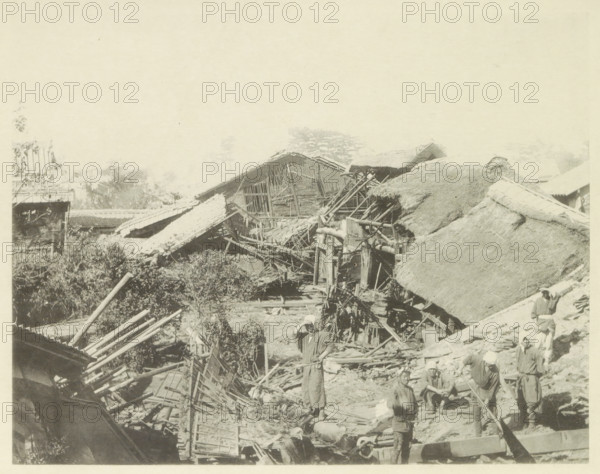 Destroyed houses in Biwajima after an earthquake, page, photomechanical print, Japan, cliché maker: Kazumasa Ogawa, after 1891-10-28 - in or before 1892, photographer, paper, collotype, photoprint, height 222 mm x width 285 mm, ruin of a dwelling, house, castle, consequences of an earthquake, Mino–Owari Earthquake 1891, A sepia-toned scene showing collapsed and damaged thatched and tiled roofs with exposed wooden beams and broken structural elements, scattered debris and wooden poles across the ground, a group of people wearing simple clothing and head coverings standing and sitting among the rubble, one person standing near the center with a hand raised to their head, vegetation and trees visible behind the damaged buildings, and partial remnants of remaining roof sections and scaffolding throughout the image.