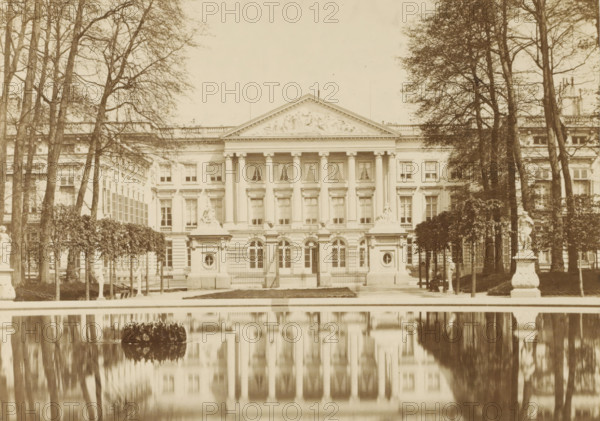 View of the facade of the Palace of the Nation in Brussels, Palais de la Nation, Bruxelles, photograph, page, name: '(Phot. de Brand frères, rue de la Madeleine, 32.)', photographer: Brand Frères, Brussels, c. 1862 - c. 1872, paper, albumen print, height 150 mm x width 205 mm, Photo on page 3., Lower House, Parliament, Chamber, pond, pool, façade (of house or building), Palace of the Nation, A sepia-toned photograph of a neoclassical building with a columned central facade and a triangular pediment decorated with sculpted reliefs, framed by tall leafless trees on both sides, a formal garden with trimmed hedges and several statues on ornate pedestals in the foreground, a reflective rectangular pool mirroring the building and trees, rows of evenly spaced windows and decorative balustrades along the roofline, and gated entrances at the base of the central section.