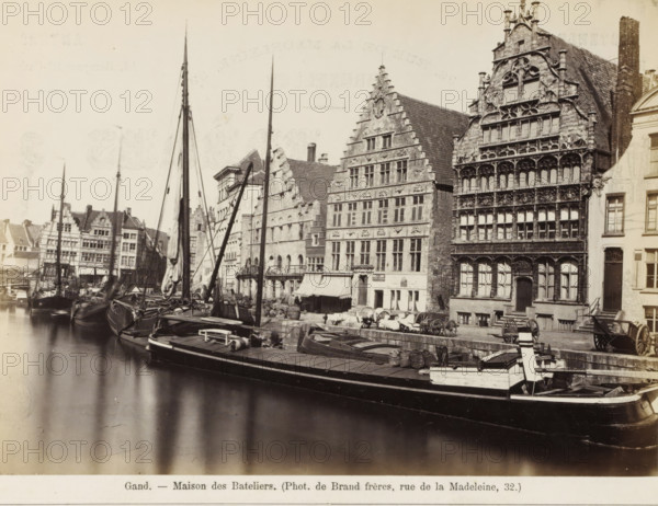 Gand - Maison des Bateliers, Portrait and a cityscape in Ghent, photograph, page, Above a portrait of a man with a beard, below a view of the Graslei in Ghent., name: '(Phot. de Brand frères, rue de la Madeleine, 32.)', photographer: Brand Freres, c. 1862 - c. 1872, Brand Frères, paper, albumen print, albumendruk, height 403 mm x width 294 mm, Photos on page 23., anonymous historical person depicted, façade (of house or building), quay, A waterfront scene showing multiple moored sailing vessels with tall masts and rigging alongside a stone quay, with cargo and equipment on deck; a row of historic multi-story buildings with ornate stepped and carved facades lines the quay, featuring many windows and decorative stonework, awnings over ground-level openings, and a few carts and barrels on the pavement; calm reflective water fills the foreground and the sky above is pale.