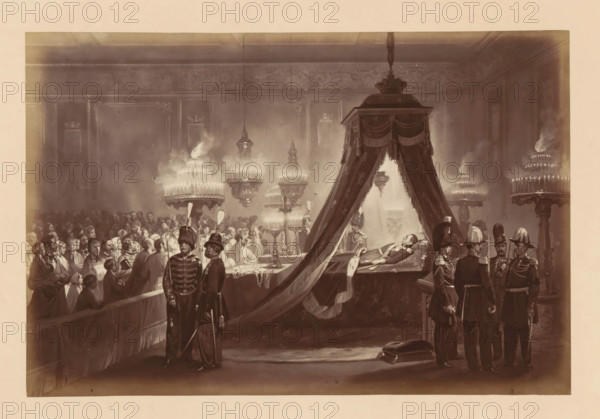 Photographic reproduction of a design of the laid-out body of King Léopold I of Belgium in the Royal Palace in Brussels, Exposition du Corps de SM Léopold 1er - au Palais de Bruxelles, photograph, reproduction, This photo is part of a cover with fourteen photos., inscription: 'Relevé de Garde.', photographer: Ghémar Frères, Brussels, after design by anonymous, c. 1861 - in or before 1866, paper, albumen print, height 168 mm x width 250 mm, Person, Leopold I (King of the Belgians), funerary ceremonial, king, Royal Palace (Brussels), Period, 1865-12, A large dimly lit interior scene shows a long room with ornate walls and high ceiling, filled with people gathered around a raised platform draped with heavy curtains. On the platform a man lies on a decorated bier beneath a canopy, dressed in formal attire and wearing medals, while attendants stand nearby in dark military uniforms with plumed helmets. Rows of seated and standing figures fill the left side of the room, many wearing head cove...