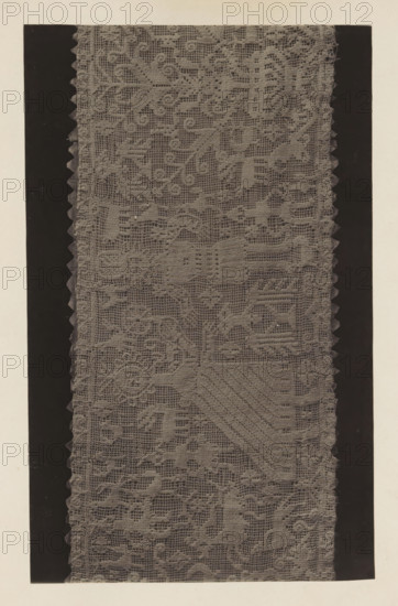 German scene in lace from the collection of Antonin Terme, photograph, page, Liège, c. 1880 - in or before 1885, photographer, paper, platinum process, height 138 mm x width 224 mm, lace, art collection, art gallery, A vertical strip of patterned lace fabric runs down the center, showing a detailed open weave with repeating floral and geometric motifs and scalloped edges on both sides; the lace appears in a muted gray tone against darker vertical bands that frame it, and a light neutral background surrounds the framed area.
