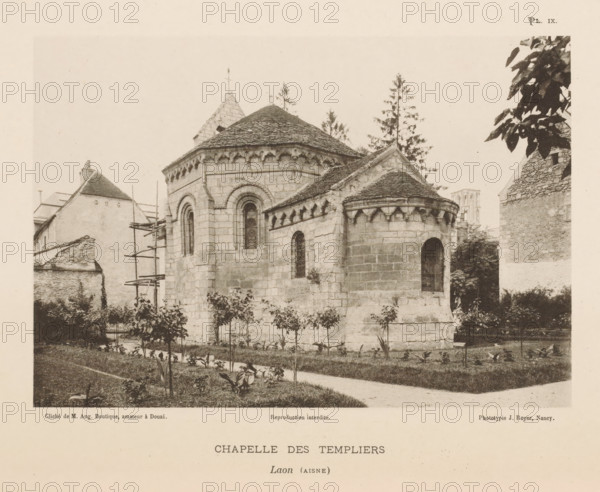 View of the Templar Chapel in Laon, France, Chapelle des Templiers, Laon (Aisne), page, photomechanical print, number: 'Pl. IX.', inscription: 'Reproduction interdite.', maker: Jules Royer, maker: Augustin Boutique, Douai, c. 1891 - in or before 1896, paper, collotype, photoprint, height 118 mm x width 171 mm, Print on third unnumbered page after page 6., parts of church exterior and annexes: chapel - QQ - small church, chapel, A sepia-toned photograph of a stone chapel with rounded apses and steep tiled roofs, showing carved corbels under the eaves and narrow arched windows with dark panes, surrounded by a grassy foreground with small plants and a narrow path, adjacent stone and plaster buildings with scaffolding visible on one side, tall trees rising behind the chapel, and leafy branches intruding from the top right edge of the image.