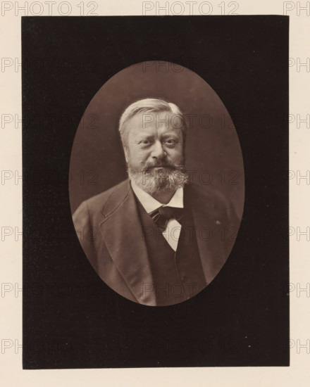 Edmond About .Ne a Dieuze (Meurthe), le 14 fevrier 1828, Portrait of Edmond About, photomechanical print, inscription: '126, boul. Magenta.-Paris.', photographer: Félix Nadar, cliché maker: Goupil & Cie., c. 1876 - in or before 1879, paper, Woodburytype, Woodburytypepie, height 201 mm x width 153 mm, Person, Edmond About, portrait of a writer, A sepia-toned oval portrait of a middle-aged man with light hair and a full beard and mustache set against a dark background, showing his head and upper torso dressed in a dark suit jacket and waistcoat over a light shirt with a visible bow or necktie, all framed by a rectangular dark mat with a light border.