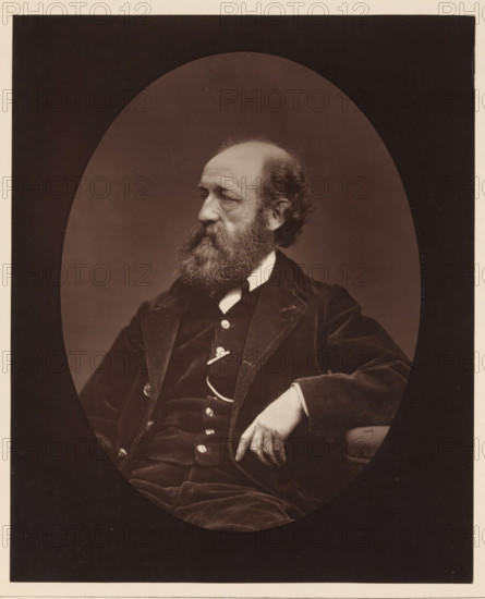 Edmond Morin. Ne au Havre, le 26 mars 1824, Portrait of Edmond Morin, page, photomechanical print, inscription: '126, boul. Magenta.-Paris.', photographer: Étienne Carjat, cliché maker: Goupil & Cie., c. 1876 - in or before 1879, paper, Woodburytype, height 228 mm x width 186 mm, Person, Edmond Morin, portrait, self-portrait of artist, A sepia portrait of a seated older man shown in an oval frame against a dark rectangular background, turned in three-quarter profile to his left, with a full beard and thinning hair, wearing a dark corduroy jacket and waistcoat with visible buttons and a light shirt collar, his right arm resting on an armrest and his right hand relaxed with fingers slightly curled, the lighting highlighting facial texture and the fabric details of his clothing.