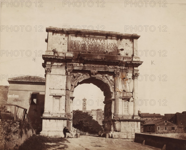 Arco di Tito (Rome), Triumphal Arch of Titus in Rome, Italy, photograph, collector's mark: 'RIJKS SCHOOL VOOR KUNSTNIJVERHEID, GROEP', number: '22', number: 'No. 1026.', photographer: attributed to Giorgio Sommer, Rome, 1857 - 1914, Giorgio Sommer, photographer, Attributed to, pasteboard, paper, albumen print, height 319 mm x width 479 mm, ruin of a building, architecture, triumphal arch, Arch of Titus, A large stone triumphal arch dominates the scene, showing a wide central opening with ornate carved details and weathered surfaces; fluted columns with decorative capitals flank the arch and support an entablature with a rectangular panel above it; patches of vegetation and dark stains appear on the stone, and some sculpted relief elements are visible around the archway. To the left of the arch a building with a tiled roof and a barred window sits partially in view, with a narrow staircase and railing leading up beside it. Through the arch opening a tree-lined avenue extends toward a di...