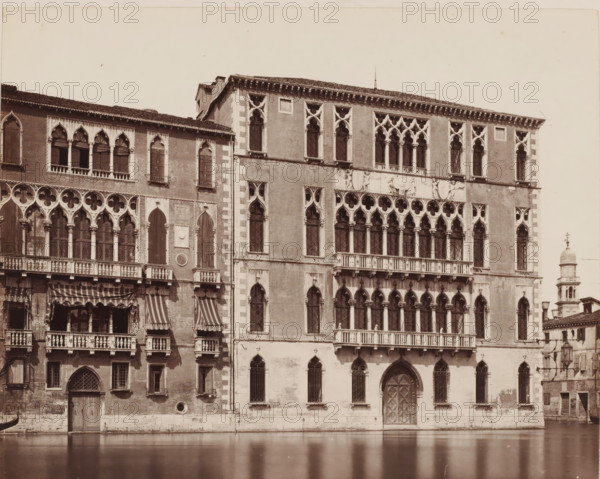View of the Palazzo Foscari in Venice, Italy, Palazzo Foscari (Venezia), photograph, inscription: 'Venetie, Venetia', collector's mark: 'RICH SCHOOL FOR ART HANDBOOK, GROUP', inscription: 'I', number: 'No. 3532.', number: '41', photographer: attributed to Giorgio Sommer, Venice, 1857 - 1914, Giorgio Sommer, photographer, Attributed to, pasteboard, paper, albumen print, albumendruk, height 319 mm x width 480 mm, hôtel, ie small palace in city, Ca' Foscari, A sepia-toned photograph of an ornate stone building facade facing a canal, showing multiple levels of arched windows and balconies with decorative columns and tracery, a large carved central doorway with a pointed arch, striped fabric awnings over some balcony openings, patterned window grilles, rectangular and arched window openings with stone surrounds, sculpted relief panels and ornate cornices near the roofline, a narrow vertical section with lighter masonry at a corner, and a bell tower with a domed top visible beyond the buildi...