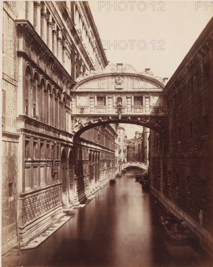 Ponte dei Sospici. (Venezia), View of the Bridge of Sighs in Venice, Italy, photograph, number: '3519.', collector's mark: 'RIJKS SCHOOL FOR ARTS HANDBOOK, GROUP', inscription: 'Burg der Zuchten', inscription: 'I', photographer: attributed to Giorgio Sommer, Venice, 1857 - 1914, Giorgio Sommer, photographer, Attributed to, pasteboard, paper, albumen print, height 478 mm x width 318 mm, landscape with bridge, viaduct or aqueduct, canals, waters (in city), Ponte dei Sospiri, A narrow canal runs between two tall stone buildings with an ornate covered bridge spanning across the water; the left building has rows of arched windows, decorative columns, and patterned stonework along its lower face while the right building shows large rectangular blocks and a plain facade; the bridge features sculpted reliefs, carved details, and small decorative windows above an arched passage; beyond the bridge the canal continues past additional buildings and a smaller arched bridge, and several small boats ...