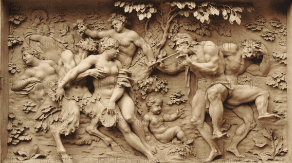 Hautrelief from Elfenbein, ein Bacchanale v. J. Elhafen. 1708, Ivory relief depicting a bacchanal, by Ignaz Elhafen, photomechanical print, number: 'Blatt 190.', Germany, cliché maker: anonymous, after sculpture by Ignaz Elhafen, printer (person): attributed to Johann Baptist Obernetter, Munich, 1869 - 1887, Ignaz Elhafen, photographer, after sculpture by, printer (person), Bavaria, Attributed to, pasteboard, paper, collotype, photoprint, height 128 mm x width 216 mm, height 415 mm x width 539 mm, piece of sculpture, reproduction of a piece of sculpture, bacchanal: Bacchus with his wine-flushed train (thiasos), A carved relief panel in a warm stone tone shows multiple partially and fully nude human figures intertwined among carved foliage and trees, with some figures wearing wreaths of leaves and one holding a cluster of grapes; a central seated female figure holds a hand near her chest and grasps a round shallow object, while a muscular male figure to the right plays a double pipe and...