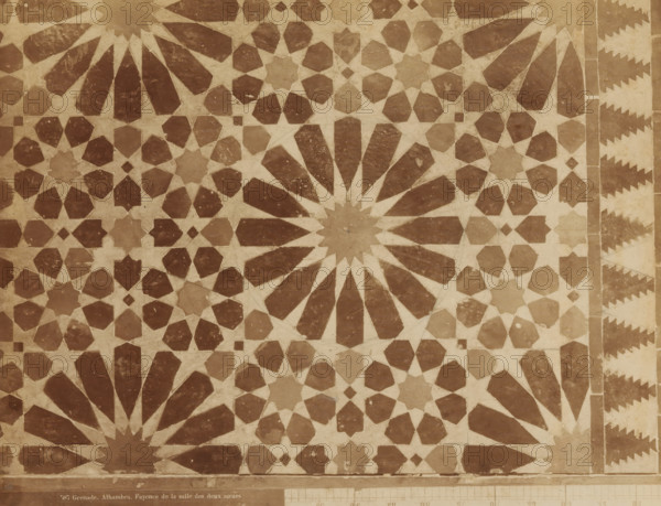 Mosaic of faience in the Hall of the Two Sisters in the Alhambra in Granada, Grenade. Alhambra. Fayence de la salle des deux soeurs, photograph, inscription: 'Syria', number: '587', Alhambra, c. 1875 - c. 1900, photographer, Andalusia, Granada, paper, pasteboard, albumen print, height 217 mm x width 279 mm, ornament, starforms, art (mosaic making), flat decoration, applied arts (Islamic art), A flat surface covered with a repeating geometric mosaic pattern in two contrasting tones, featuring large radial starburst shapes with elongated petal-like segments, interlocking smaller star and polygon motifs, and a narrow decorative border with stepped triangular shapes along one edge, all showing slight surface wear and subtle variations in color and texture.