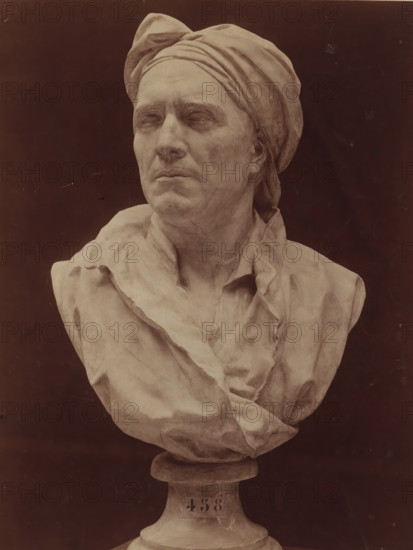 Bust of Nicolas Coustou by G. Coustou, G. Coustou Bust of Nicolas Coustou. Château de Versailles, photograph, number: 'T 458', inscription: 'Guillaume Coustou.', collector's mark: 'Rijks-SCHOOL FOR DRAWING TEACHERS AMSTERDAM', name: 'A. GIRAUDON EDITEUR 15. R. BONAPARTE PARIS', photographer: Adolphe Giraudon, publisher: Adolphe Giraudon, Paris, c. 1875 - c. 1900, Adolphe Giraudon, photographer, publisher, paper, pasteboard, albumen print, height 261 mm x width 203 mm, sculpture, historical persons ((full) bust portrait), A monochrome bust of a person wearing a wrapped headscarf and draped garment is shown against a dark background, the face turned slightly to one side with closed or blank eyes and a neutral mouth, detailed sculpted facial features and textured folds in the cloth visible, the bust rests on a rounded pedestal.