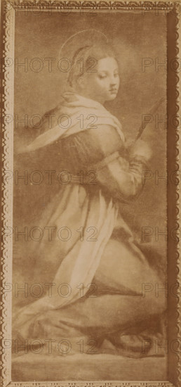 Photo reproduction of the painting of Catherine of Alexandria after Andrea del Sarto in the cathedral of Pisa, Italy, Cattedrale S. Caterina. (Andrea del Sarto), Pisa, photograph, reproduction, collector's mark: 'VOSMAER', photographer: Fratelli Alinari, publisher: Fratelli Alinari, Florence, after painting by Andrea del Sarto, 1857 - 1900, Fratelli Alinari, Andrea del Sarto, photographer, publisher, after painting by, Tuscany, pasteboard, paper, albumen print, height 249 mm x width 123 mm, height 354 mm x width 261 mm, Person, Catherine of Alexandria, picture, painting, Dom (Pisa), A vertical sepia-toned image showing a framed painting of a kneeling figure draped in flowing robes and a light shawl, turned slightly in profile with the head tilted back and eyes directed toward the viewer; the figure holds a long slender object in one hand and has a faint circular halo behind the head; soft shading defines the face, hair pulled back, and the layered folds of the garment that pool around ...