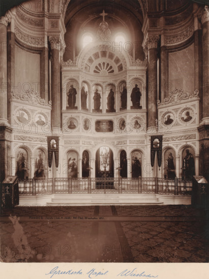 Altar of the so-called Greek Chapel in the Russian Orthodox Church on Mount Nero, Wiesbaden, Germany, photograph, Erroneously named 'Greek Chapel' part of the Russian Orthodox Church 'of Saint Elisabeth in Wiesbaden', which Adolf von Nassau had built between 1847-1855 as a tomb for his young deceased wife Elisabeta Mikhailovna (daughter of the younger brother of Tsars Alexander I and Nicholas I of Russia)., signature and date: 'Mondel & Jacob (Inh. G. Jacob) Hof-Phot. Wiesbaden 1897.', caption, inscription: 'Altar d. Griechischen Kapelle', photographer: Mondel & Jacob, photographer: Mondel, photographer: Julius Jacob, 1897, Hessen, pasteboard, paper, albumen print, albumendruk, height 282 mm x width 225 mm, height 508 mm x width 330 mm, A sepia-toned photograph of an ornately decorated interior showing a grand architectural wall with multiple arched niches and tiers, each niche containing a figure statue or painted portrait, surrounded by intricate carved moldings and decorative panels...