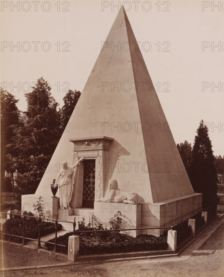 Crematorium, Cimitero Monumentale, Milan, Italy, photograph, Classical marble building, the Crematorium of the Cimetero Monumentale cemetery, Italy., caption: '9649. MILANO. Cimitero Monumentale, Crematoio, architetto Maciacchini.', caption: '(EDIZIONI BROGI)', photographer: Edizioni Brogi, Florence, publisher: Giacomo Brogi, c. 1865 - c. 1890, Tuscany, pasteboard, paper, albumen print, height 249 mm x width 200 mm, height 492 mm x width 330 mm, Lombardy, A large stone pyramid structure fills most of the image, with smooth, angled faces and a sharp apex. At the base of the pyramid is a decorated doorway framed by carved relief panels and a horizontal lintel. A life-sized draped female statue stands beside the doorway, one arm raised to touch the frame and the other resting near a tall vase on a pedestal. In front of the doorway, a recumbent sphinx sculpture lies on a raised platform, facing outward. The pyramid rests on a stepped base surrounded by low stone walls and a wrought metal f...